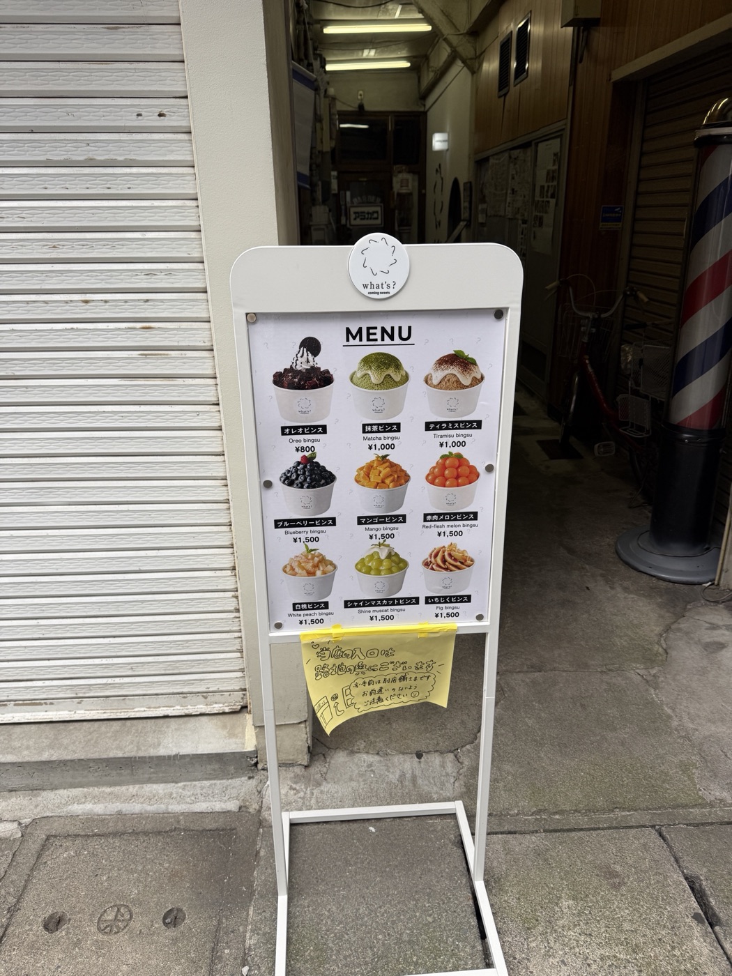 通りに出ている白いメニュー看板と路地